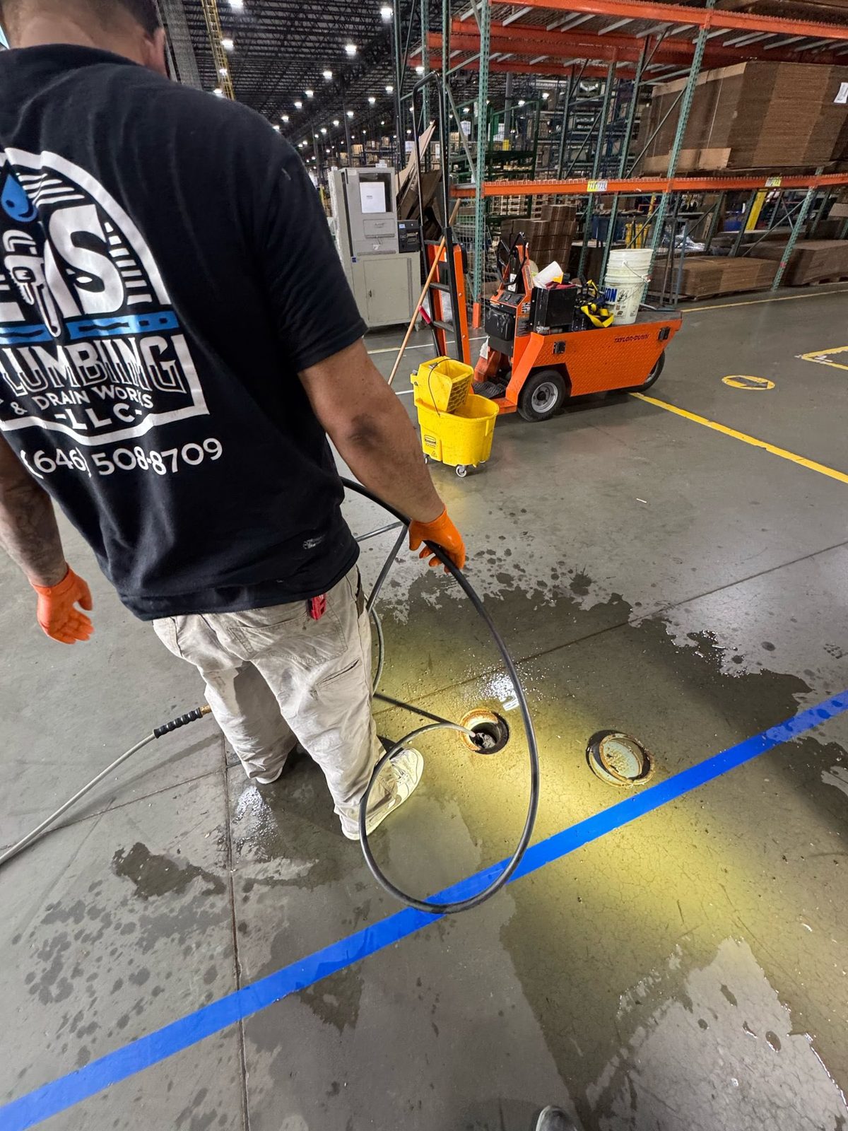 ZIS Plumbing technician running a drain cable to clear a clogged line