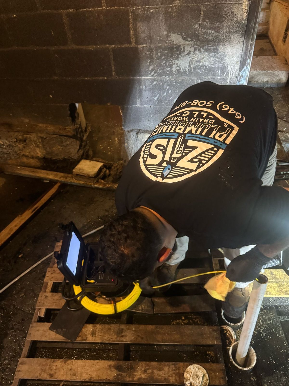ZIS Plumbing technician working underground on a trenched pipe repair